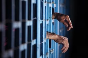 Hands sticking out of prison cell