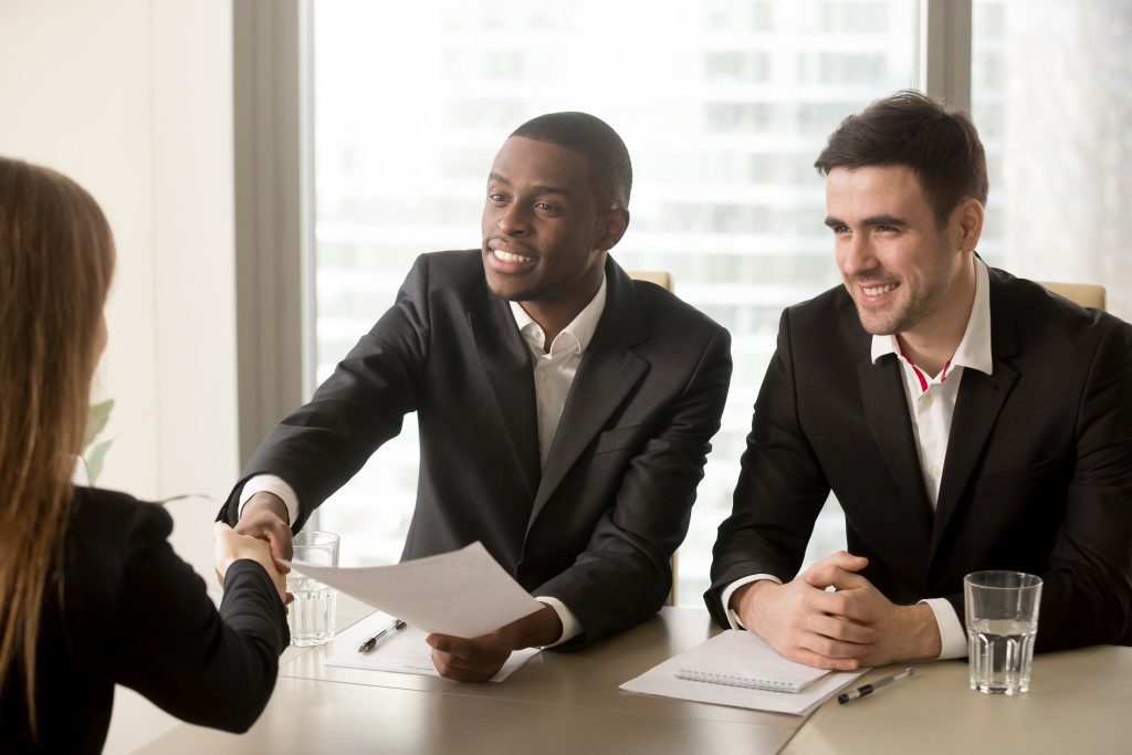 two men interviewing a girl