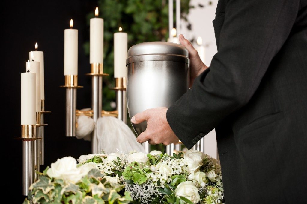 man holding an urn at a funeral