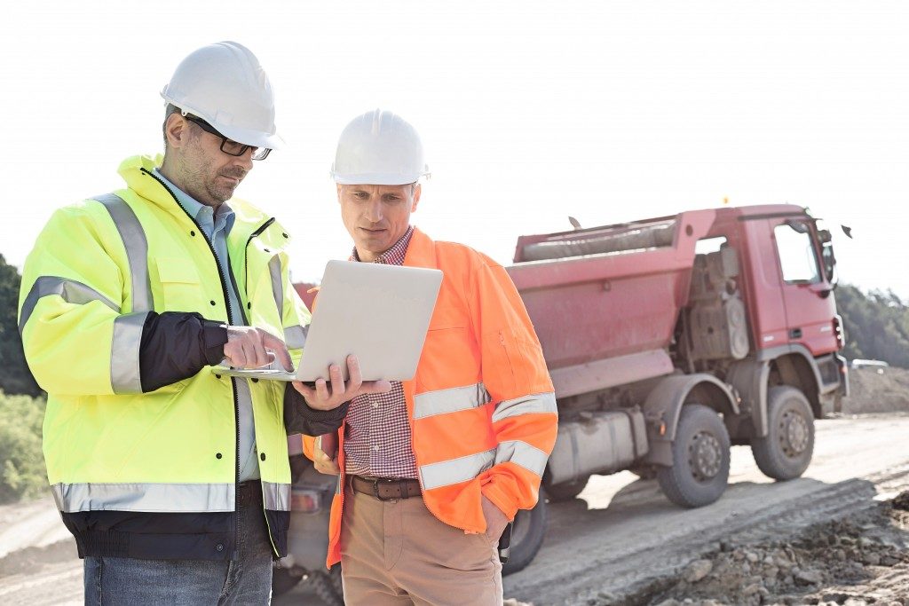 Engineers using laptop at construction site