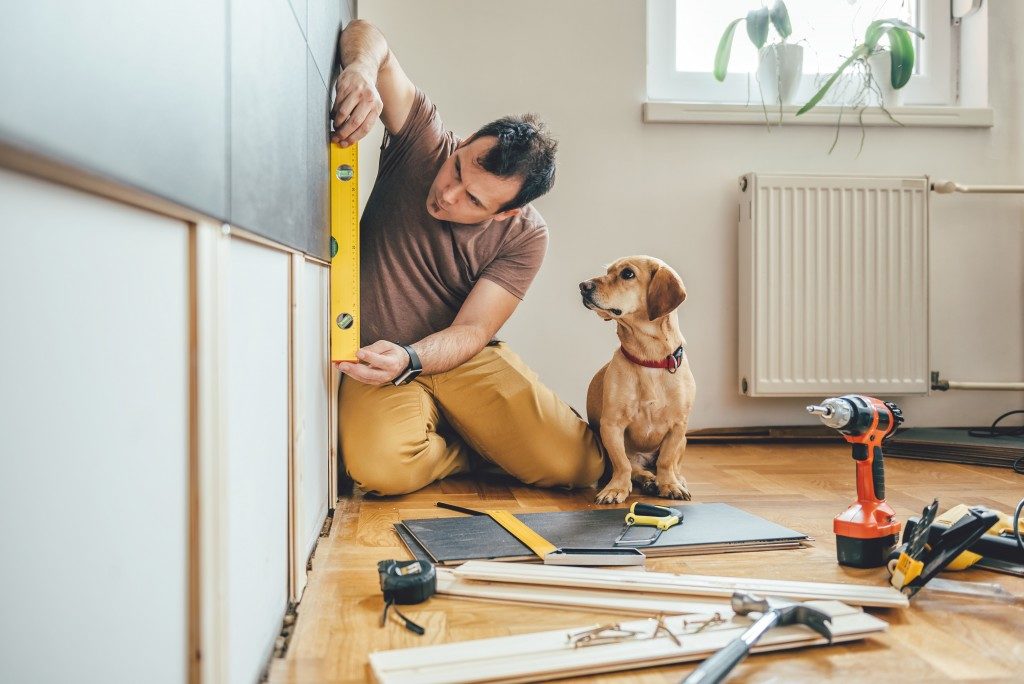 man fixing the wall with his tools