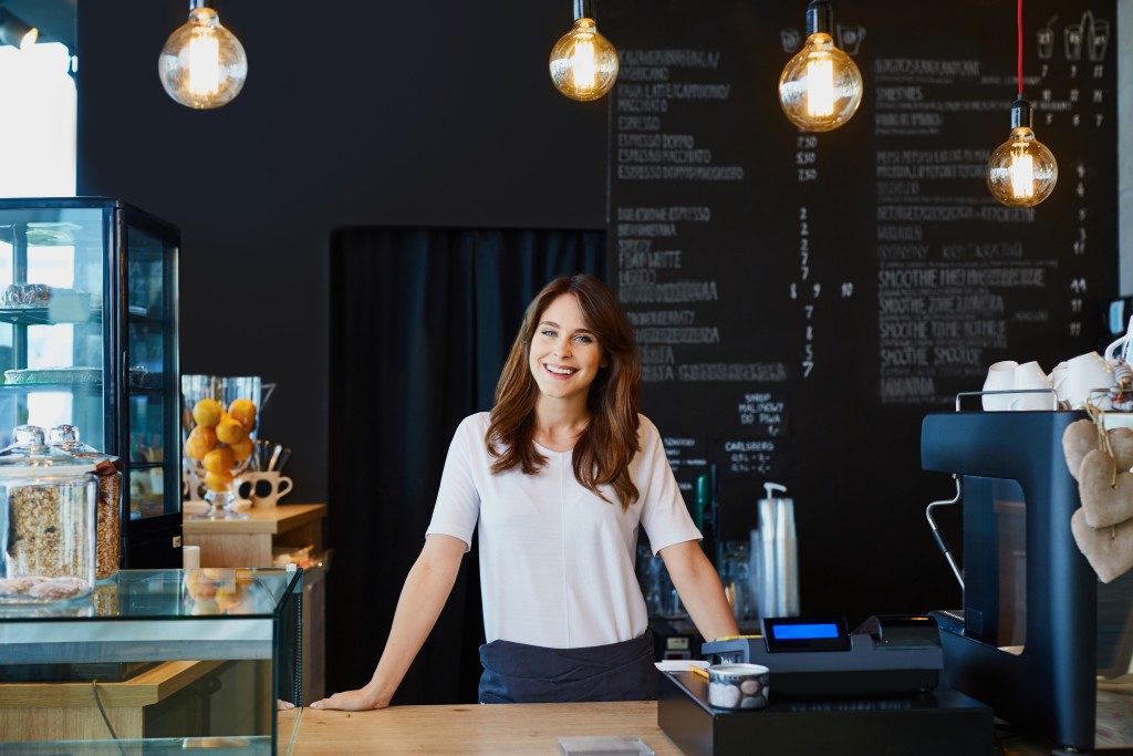 Woman standing behind cafe cashier