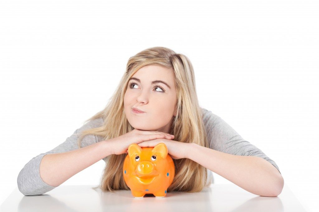 Image of woman posing with piggy bank.