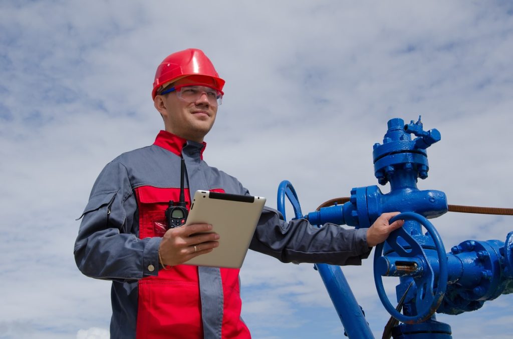 man with clipboard working with pump