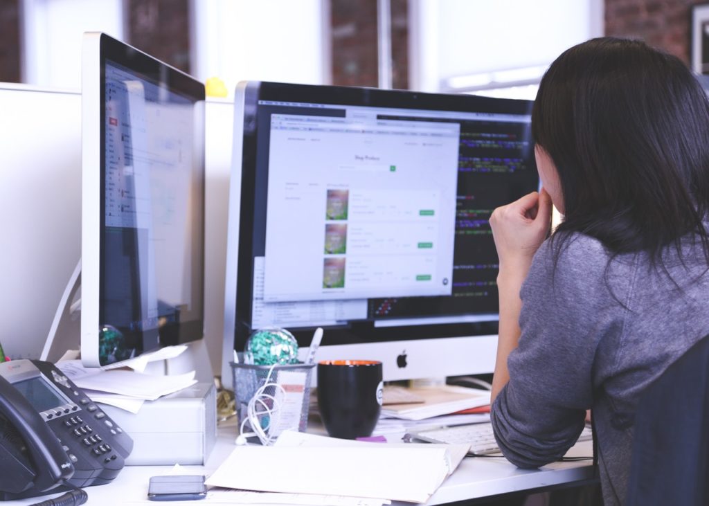 woman looking at a computer monitor